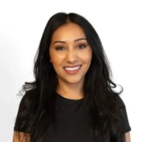Headshot of Nadia Akram smiling and wearing a black shirt with a white background