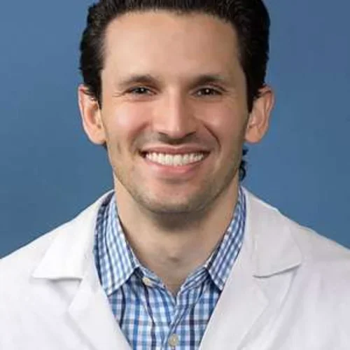 Headshot of Richard Leuchter smiling with a blue background