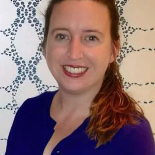 Headshot of Anne M. Walling, MD, PhD, FAAHPM, smiling against a background with a patterned design