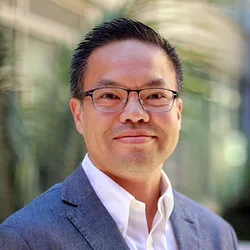 Headshot of Alex Bui smiling and wearing glasses.