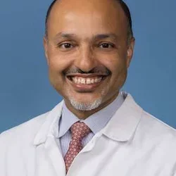 Headshot of Kenrik Duru, MD, MS, smiling with a blue background
