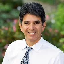 Headshot of Ralph Gonzales with a blurred garden in the background