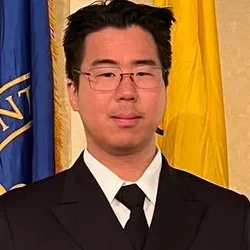 Headshot of Noah Kojima smiling and wearing glasses