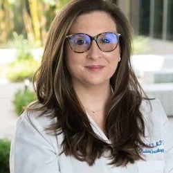 Headshot of Ann C. Raldow smiling with glasses in a white shirt. 