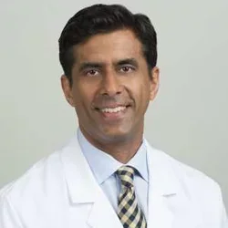 Headshot of Christopher S. Saigal, MD, smiling with a beige background.